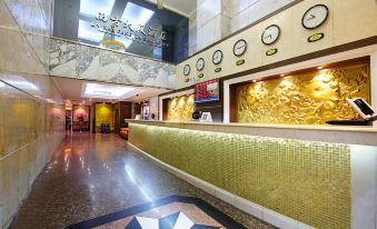 The lobby features a large clock on the wall and marble tiled floors at Na Fang Da Sha Hotel