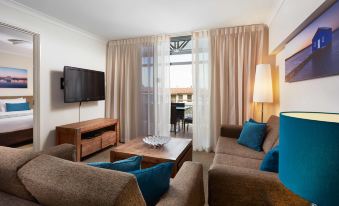 a living room with a couch , chair , and coffee table in front of a television at Broadwater Resort Como