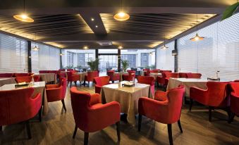 A restaurant has been set up with red and white chairs around the center table in the dining room at Howdy Smart Hotel (Chengdu Chunxi Taikoo Li)