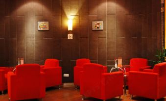 In the middle of the room, there are red chairs and tables, accompanied by an illuminated wall at Byfond Hotel