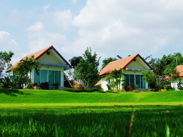 a beautiful rural landscape with two white houses surrounded by lush green grass and trees at Vimannam Resort