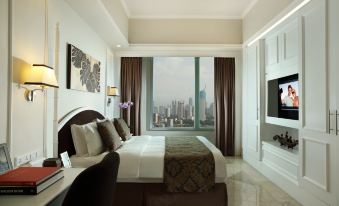 a luxurious hotel room with a king - sized bed , a flat - screen tv , and a large window overlooking a city at Ascott Jakarta