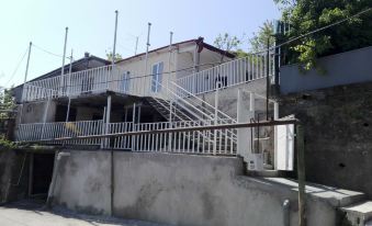 a house with a white metal staircase leading to the entrance , surrounded by a fence at Veranda