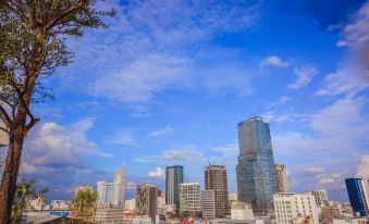 a city skyline with tall buildings , blue skies , and green trees , under a clear sky at Cochin Zen Hotel