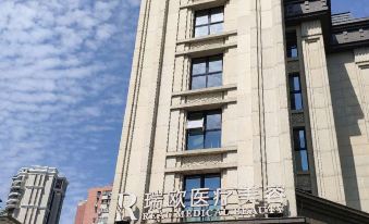 On a sunny day in an urban setting, there are impressive front and side views of large buildings at Citadines Apart Hotel (Shanghai Yan'an West Road)