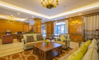 a well - decorated living room with wooden furniture , including two couches , a coffee table , and a dining table at Westlake Hotel & Resort Vinh Phuc