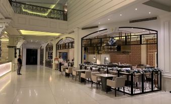 a large , modern restaurant with multiple dining tables and chairs , as well as a kitchen area at The Monarch Hotel