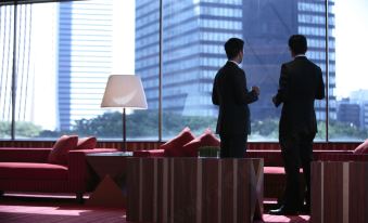 A man and a woman are standing in front of a window, observing another person who is sitting on top of something at Hilton Guangzhou Tianhe