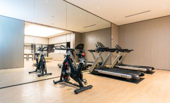 a well - equipped gym with a variety of exercise equipment , including treadmills , stationary bikes , and weight machines at Ji Hotel