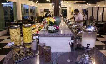 a man working at a buffet table in a restaurant , preparing food for guests at Marina Island Pangkor Resort & Hotel