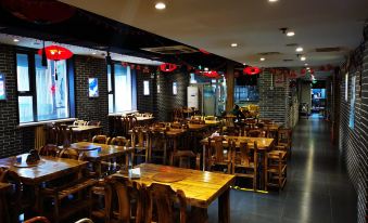 The restaurant features wooden tables and chairs in the center, as well as additional seating areas at Super 8 Hotel Premier (Beijing Workers' Stadium Sanlitun Chunxiu Road)