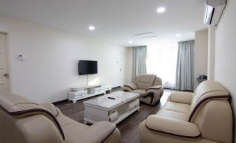 a modern living room with white walls , hardwood floors , and a large flat - screen tv mounted on the wall at Higher Hotel