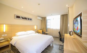 The bedroom features a double bed and a large window, with an adjacent bathroom that includes a spacious shower and modern fixtures at City Comfort Inn (Xiangyang Railway Station)