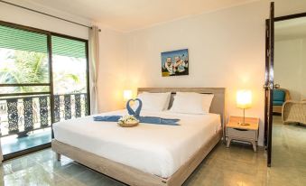 a large , well - made bed with a white comforter and two nightstands on either side of it at Dolphin Bay Beach Resort