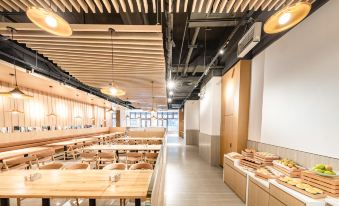 The restaurant features long tables and a wood-paneled ceiling in an open space, showcasing its interior design at Atour Hotel (Shenzhen Nanshan Vanke Yuncheng)
