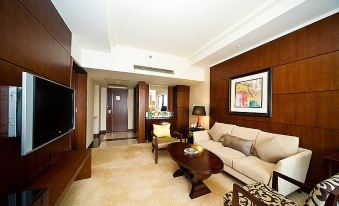 The large room is furnished with a couch, chair, and table, and it has an attached bedroom at Hotel Fortuna