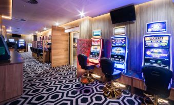 a room with two chairs and a tv , one of which is playing a video game at Airlie Beach Hotel