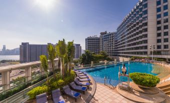 There is a large swimming pool in the center, surrounded by buildings and hotels on both sides at Harbour Plaza Metropolis