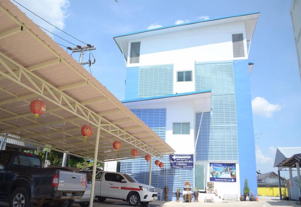 a white and blue building with a parking lot in front of it , under a clear blue sky at Tulip Place