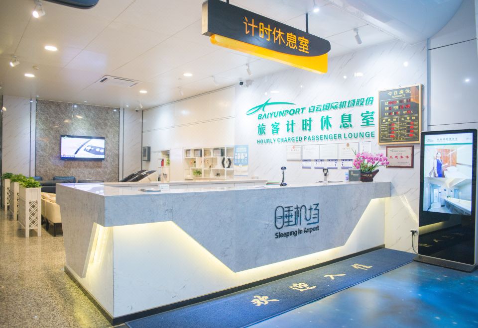 The front desk is located next to a restaurant with a visually appealing wall design at Guangzhou Baiyun Airport Passenger Time Lounge (T1 Terminal Store)