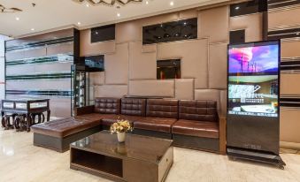 The entertainment area features a modern living room with a large TV and couches in the center at Motai Hotel (Shanghai Hongqiao International Exhibition Center Jiuxing)