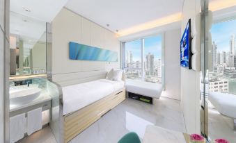 A picture of a bedroom with two beds and an open window at the end is shown at iclub Mong Kok Hotel