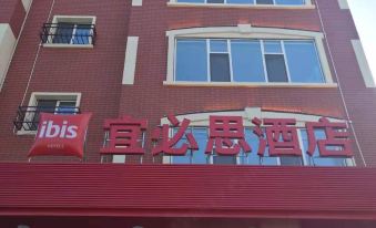 "a red and white striped building with the word "" ibis "" on it , located in a city street" at Ibis Hotel