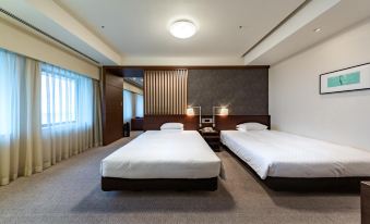 a hotel room with two beds , one on the left and one on the right side of the room at Centrair Hotel