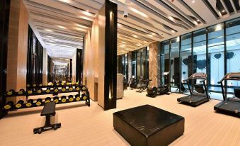 a modern gym with various exercise equipment , including treadmills and weight machines , as well as a yoga mat on the floor at The One Hotel