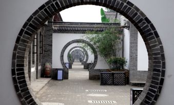 There is an archway in the walled city with white walls and a wooden gate at one end at 7 Sages International Youth Hostel
