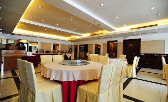 a large dining room with round tables and chairs arranged for a group of people to enjoy a meal together at Airport Hotel