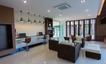 a modern living room with white walls , wooden floors , and a large window overlooking the ocean at Siva Royal Hotel