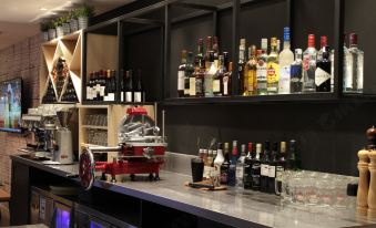 The bar is equipped with a variety of bottles displayed on shelves behind it at Campanile Hotel (Shanghai The Bund)