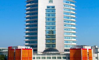 a large building with an interesting design on the front and side, containing various amenities and facilities at Longyou International Grand Hotel