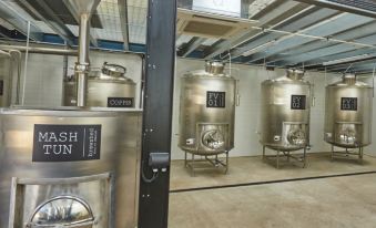 "a modern winery with stainless steel tanks and tanks for mixing and storage , as well as a large metal sign reading "" mash tun "" on the" at The Cadogan Arms
