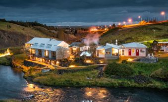 a small town with a river running through it , illuminated by street lights at night at Frost and Fire Hotel
