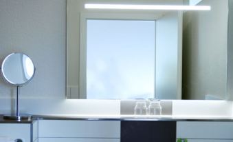 a bathroom sink with a glass shelf and a mirror reflecting the window , creating a clean and modern atmosphere at Loewen