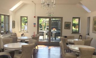 a dining room with several tables and chairs arranged for a group of people to enjoy a meal together at The Selsey Arms