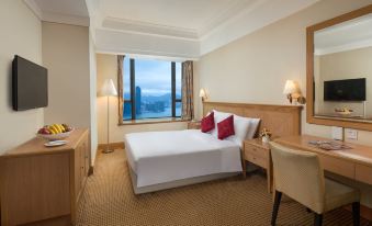 The room features a double bed and a large window with a city view on one side at Ramada Hong Kong Grand View