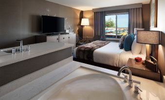 a modern hotel room with a large bed , television , and a bathtub in the bathroom at Hotel Hermosa