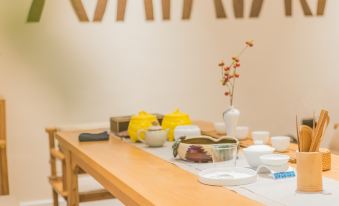 A table in the dining room is set with cups and saucers for tea or coffee at Ceramik Hotel (Foshan Lecong Furniture City)