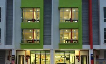 a modern apartment building with multiple windows , a black car parked in front , and people walking in front of it at Sun Inns Hotel Ayer Keroh