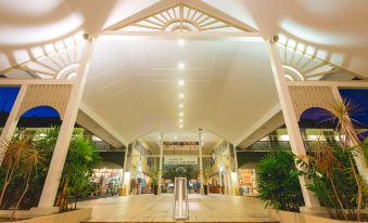 a large , open space with a white archway and steps leading up to the entrance at Cairns Colonial Club Resort