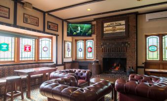 a cozy living room with leather couches and chairs around a fireplace , creating a warm and inviting atmosphere at Mick O'Sheas