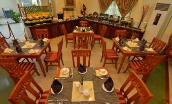 a dining room with tables and chairs arranged for a group of people to enjoy a meal together at Grand Palace Hotel