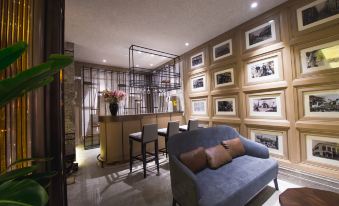 The living room features chairs and tables in the center, accompanied by an open concept kitchen at Metropolo Jinjiang Hotel Classiq (Shanghai Nanjing Road Pedestrian Street)