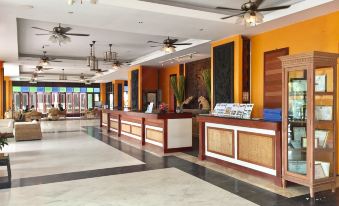 a hotel lobby with a large reception desk and several chairs arranged around it , creating a welcoming atmosphere at Pattawia Resort & Spa, Pranburi