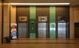 There is a lobby with two elevators positioned next to each other, with an additional elevator in the background at Covillea Bukit Jalil Room