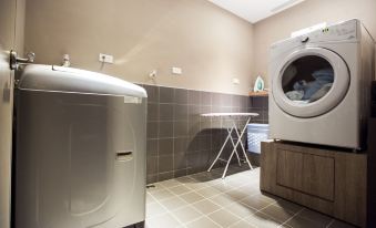 a modern , minimalist laundry room with a washing machine and dryer , as well as a tiled floor at Airline Inn Kaohsiung Station