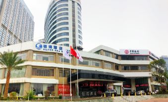 a large building with multiple flags flying in front of it , likely promoting a business or organization at Silver Sea Hotel